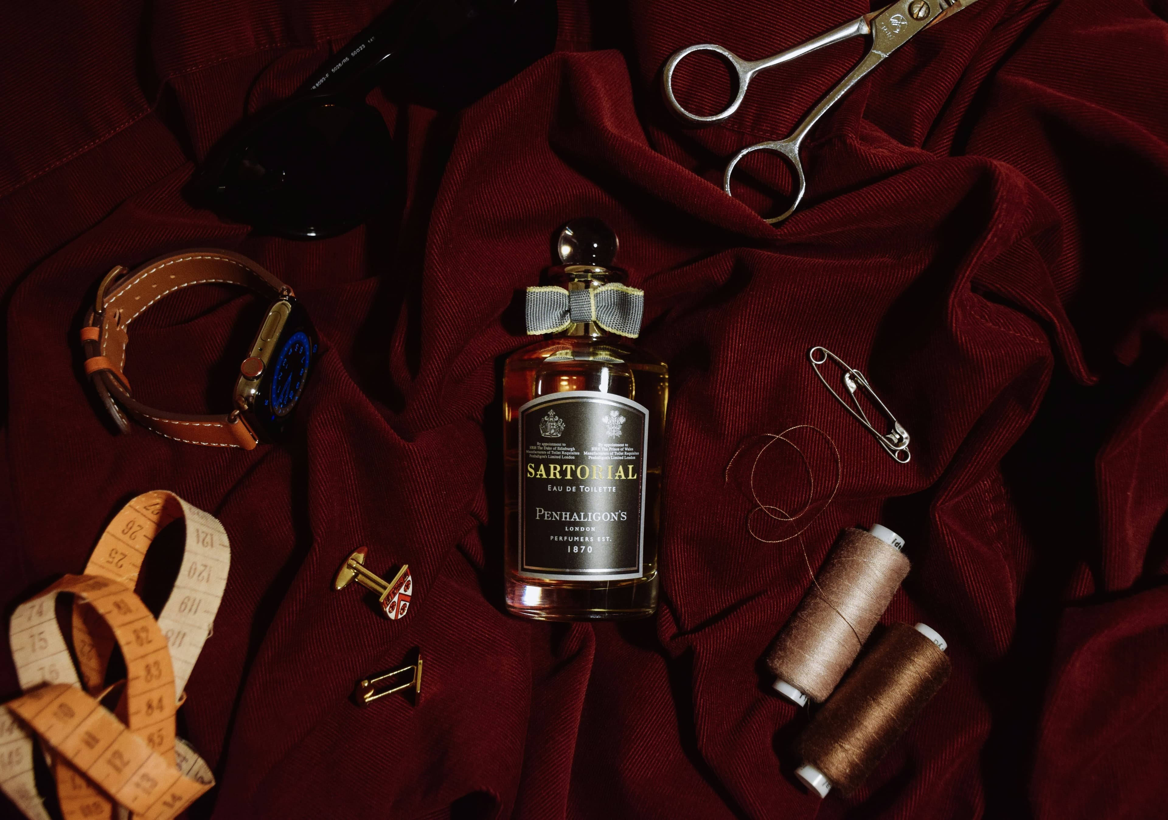 Tailoring tools arranged on burgundy fabric